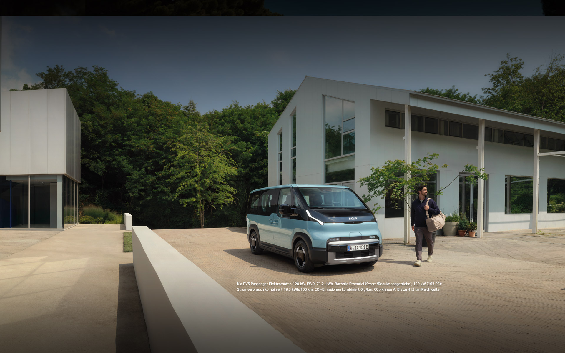 Der Kia PV5 Passenger von vorne rechts vor einem modernen Familienhaus